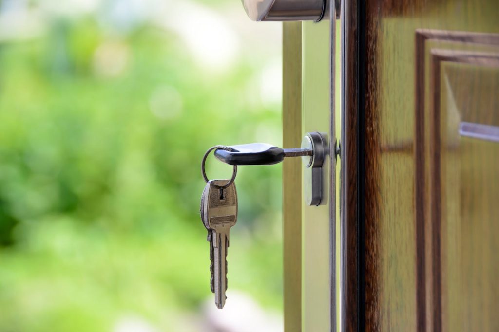 pexels-photo-101808 Key inserted in door lock against a blurred green background, symbolizing security and real estate.